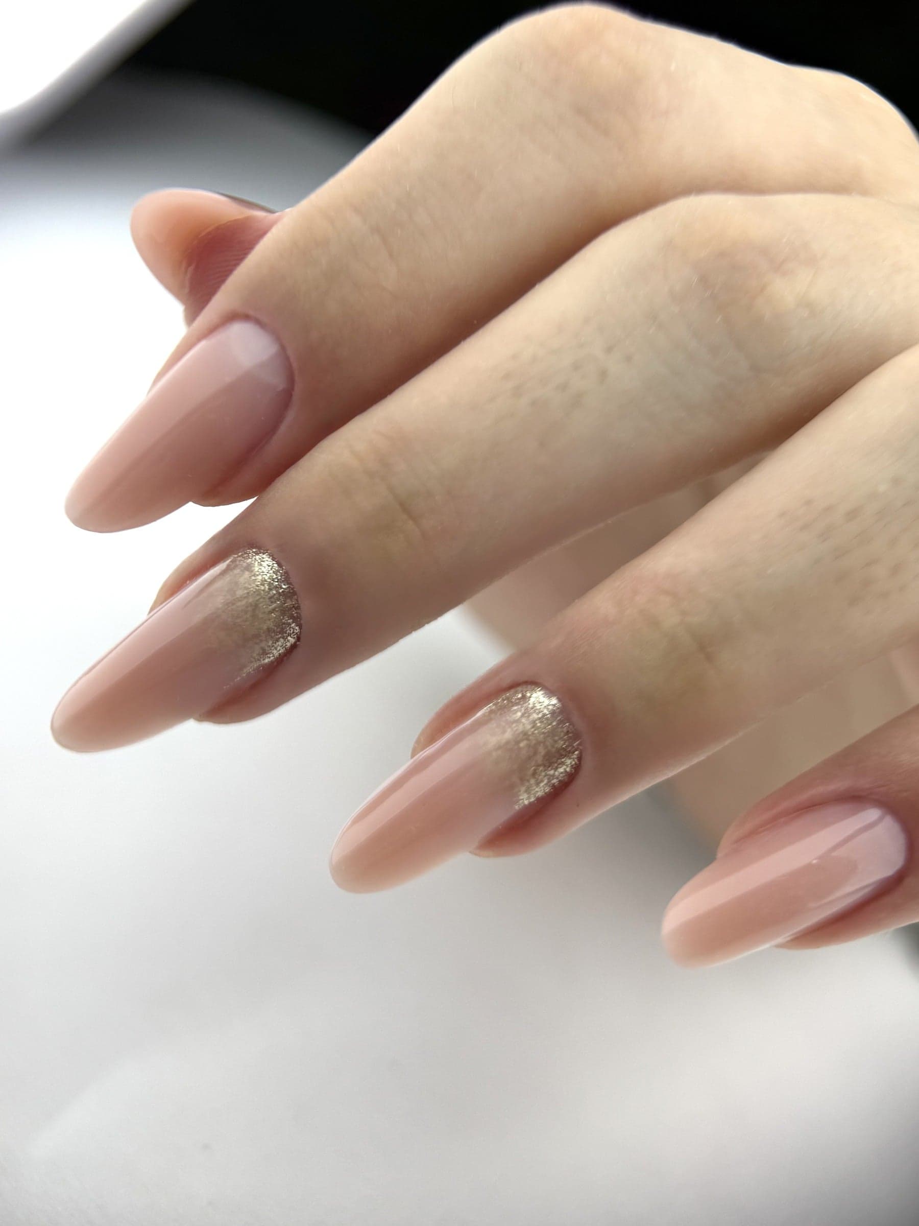 Unhas alongadas em tom nude com detalhes dourados